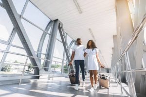 On way to honeymoon. African-american couple travelers with suitcases at airport, freee space